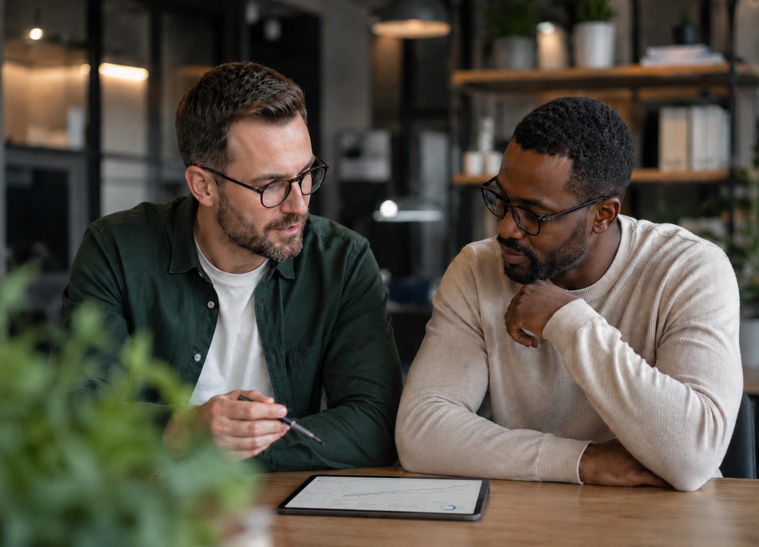 Two project leaders reviewing a delivery trend chart on a tablet during a planning discussion